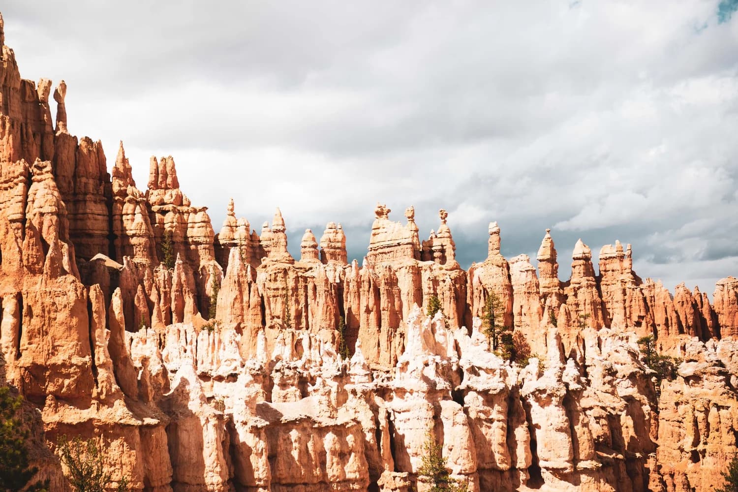 Sunlit sandstone spires beneath a dramatic sky